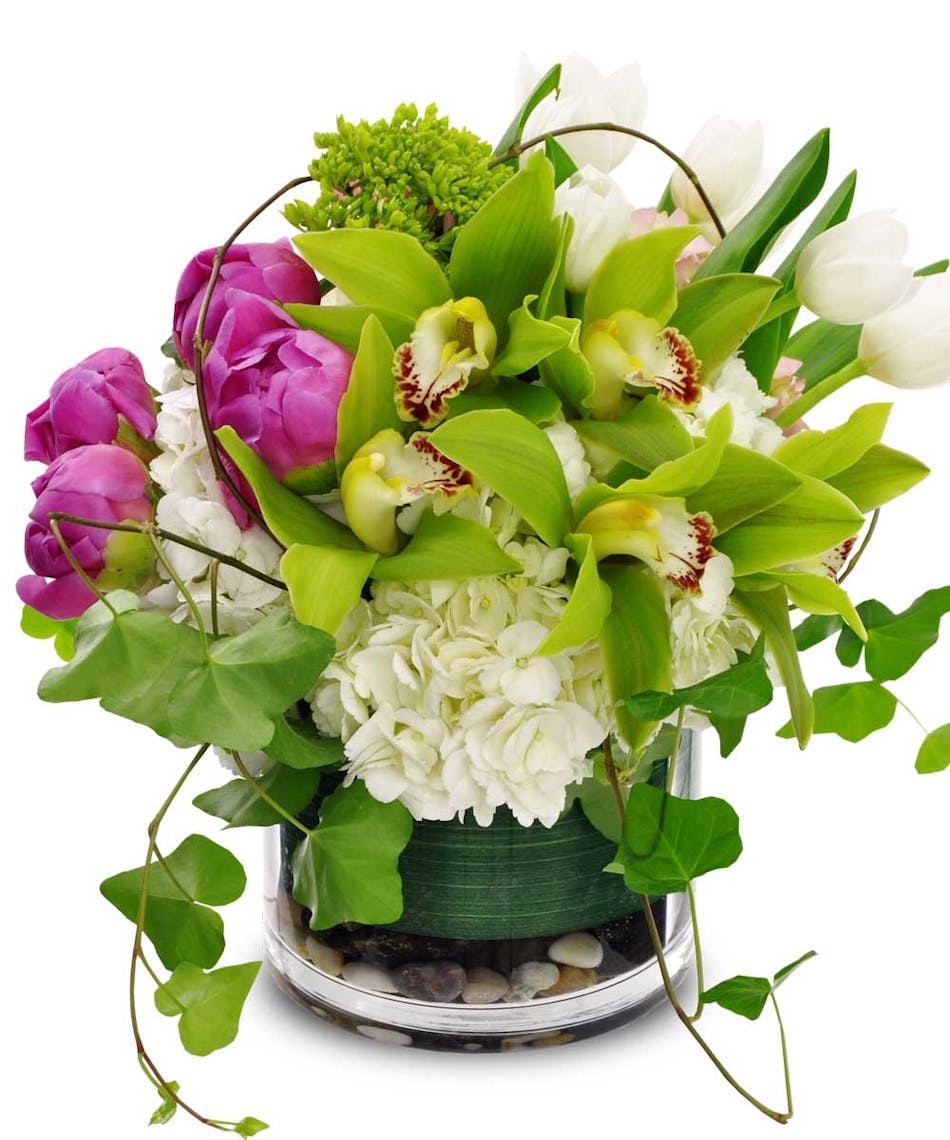Peonies, orchids, tulips & hydrangea in shades of green, pink and white in a cylinder vase.