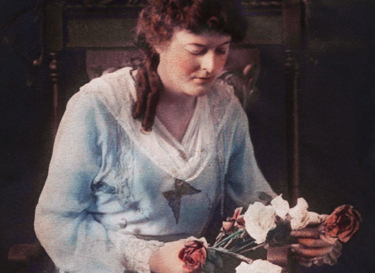 An early-century portrait of Mrs. Boswell, arranging flowers in the shop